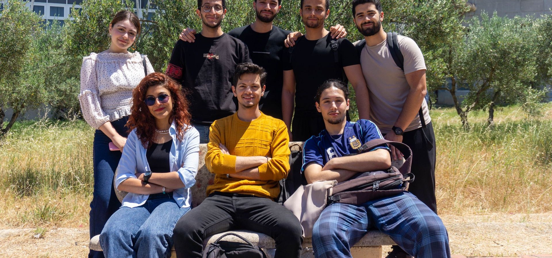 Un grupo de personas jóvenes sonríe junta al aire libre